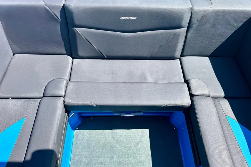 Slide: The Image of 2021 MasterCraft NXT24 boat interior with sleek gray seating and blue accents. - 40