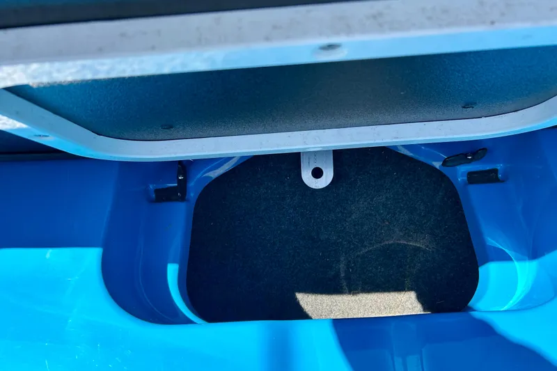 Slide: The Image of Interior storage compartment of a 2021 MasterCraft NXT24 boat, featuring blue and black design. - 44