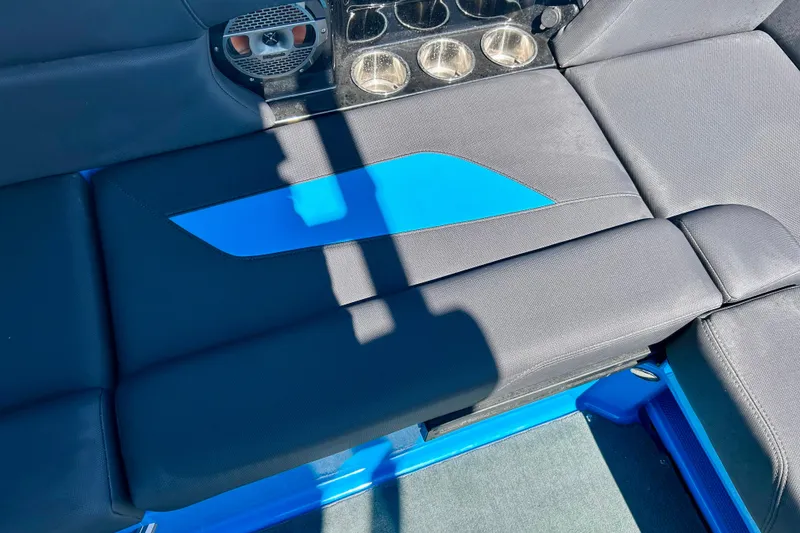 Slide: The Image of 2021 MasterCraft NXT24 boat interior with black and blue seating and cup holders. - 57