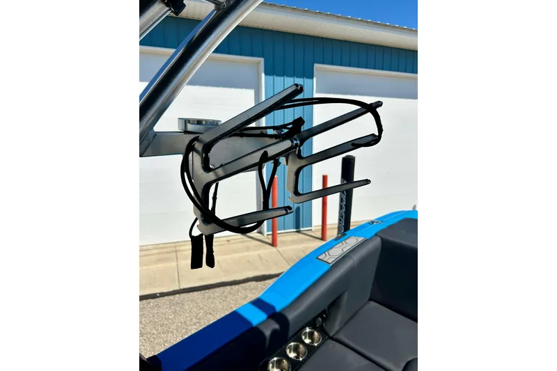 Slide: The Image of 2021 MasterCraft NXT24 wakeboard rack on blue boat, outdoor setting. - 59