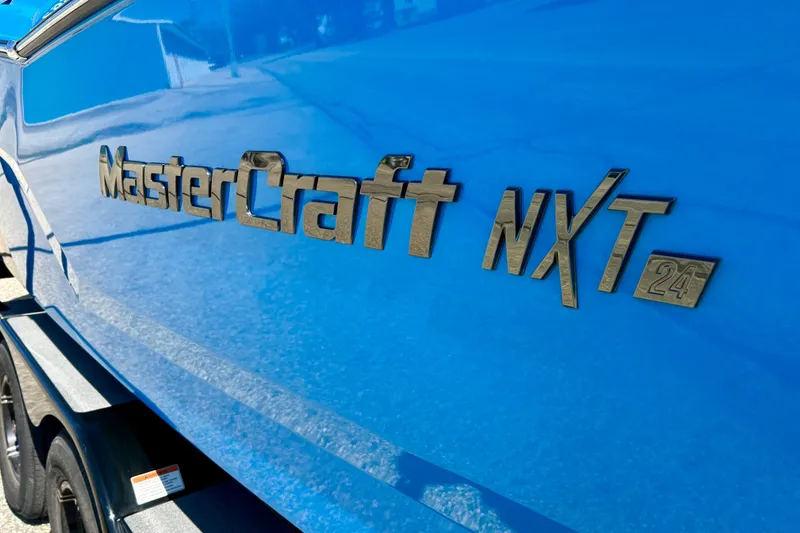 Slide: The Image of Blue 2021 MasterCraft NXT24 boat with logo detail on the side. - 8