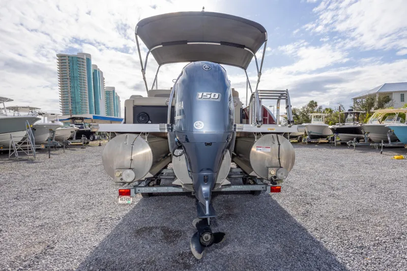 Slide: The Image of 2021 Barletta C24UC pontoon boat with Yamaha 150 engine, parked in a marina. - 11