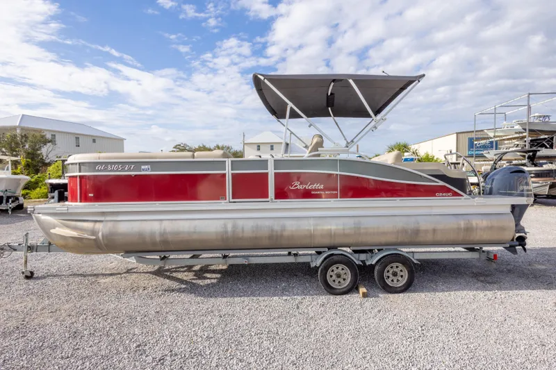 Slide: The Image of 2021 Barletta C24UC pontoon boat with canopy on trailer, parked outdoors. - 16