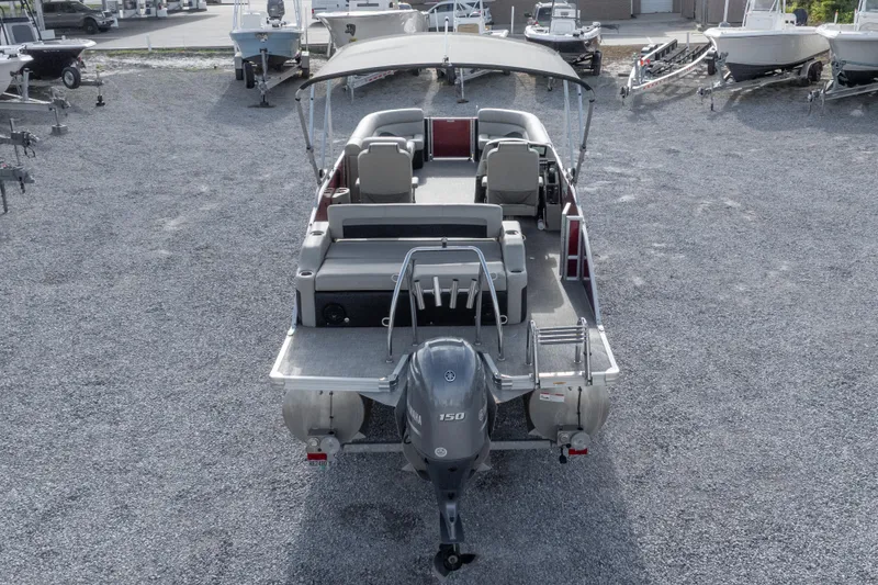 Slide: The Image of 2021 Barletta C24UC pontoon boat with Yamaha 150 engine, parked on gravel lot. - 20
