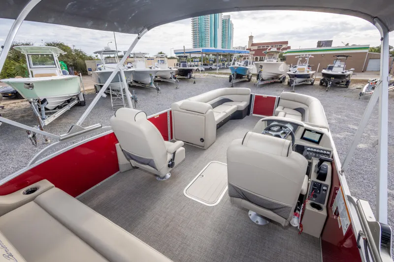 Slide: The Image of 2021 Barletta C24UC pontoon boat interior with beige seating and modern dashboard. - 26