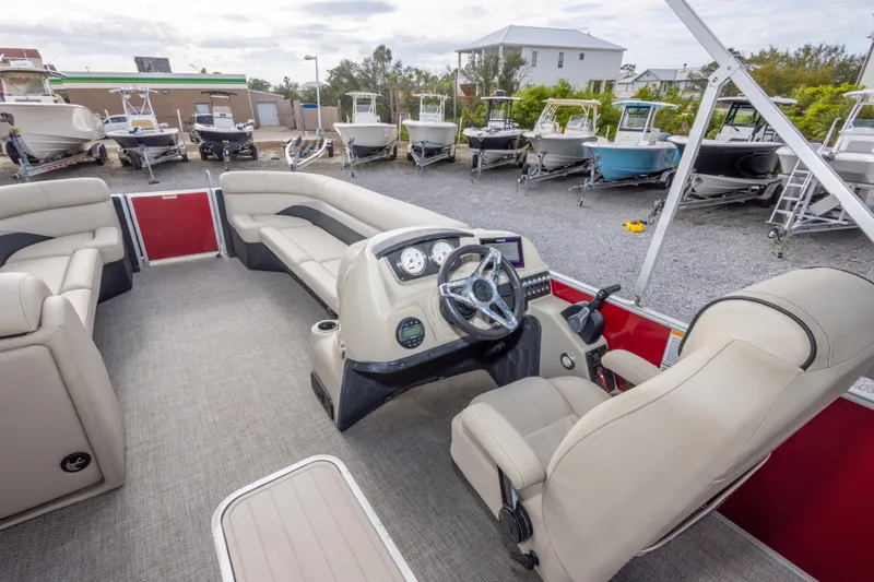 Slide: The Image of Interior view of a 2021 Barletta C24UC pontoon boat with beige seating and steering console. - 28