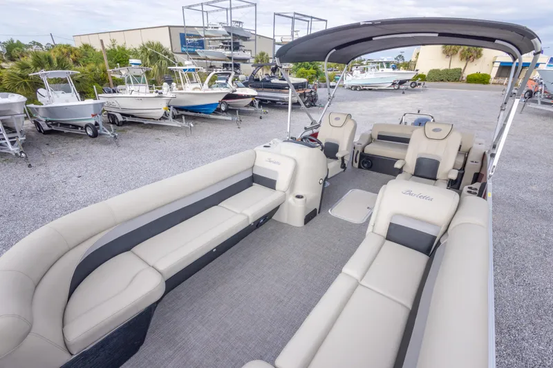 Slide: The Image of 2021 Barletta C24UC pontoon boat with spacious seating, parked in a marina. - 31