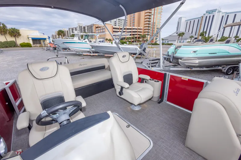 Slide: The Image of 2021 Barletta C24UC pontoon boat interior with beige seating and steering wheel. - 35