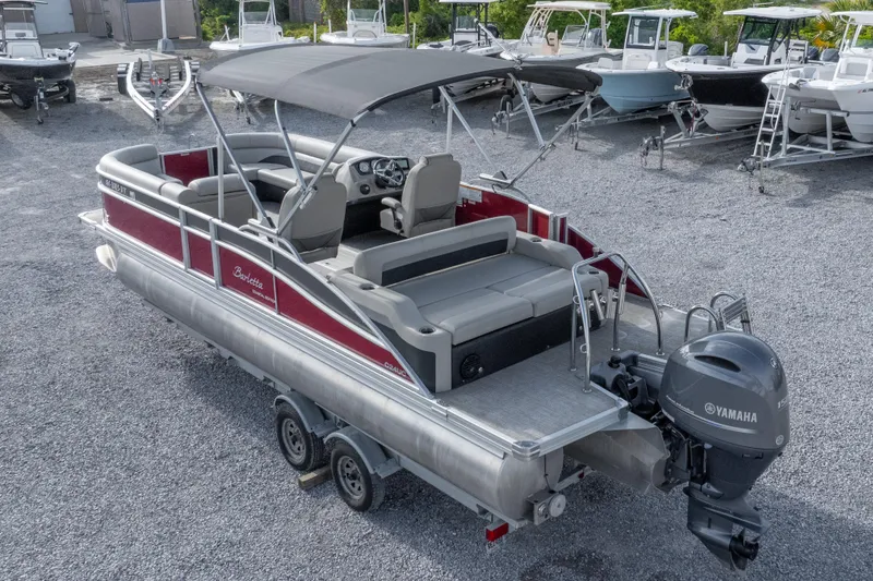 Slide: The Image of 2021 Barletta C24UC pontoon boat with Yamaha motor, parked on a trailer in a boatyard. - 4