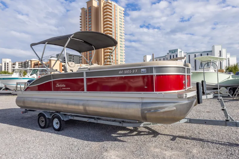 Slide: The Image of 2021 Barletta C24UC pontoon boat on trailer, urban backdrop, sunny day. - 5