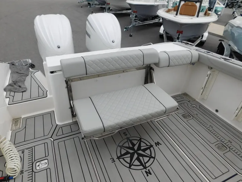 Slide: The Image of 2023 Pursuit OS 325 Offshore boat with cushioned seats and compass design. - 11