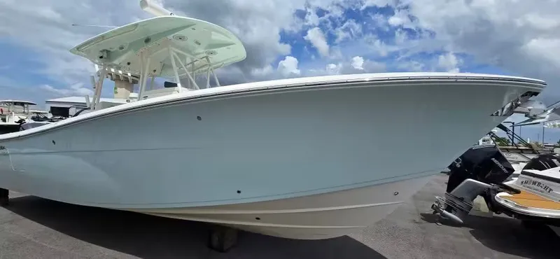 Slide: The Image of 2018 Cobia 301 Center Console boat docked, blue sky. - 4