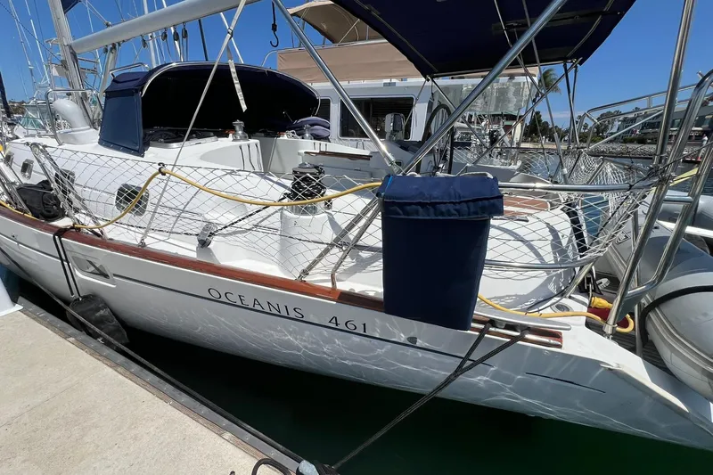 Slide: The Image of 2001 Beneteau Oceanis 461 sailboat docked at marina, featuring sleek design and netted railings. - 16