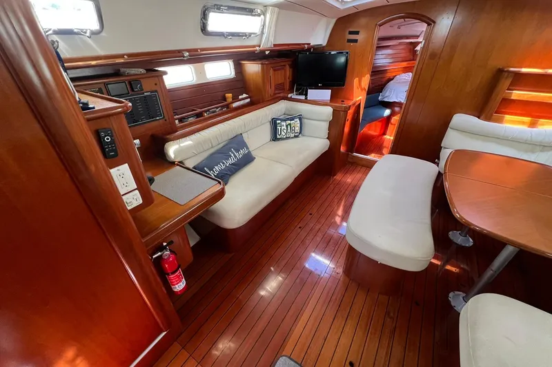 Slide: The Image of Interior of 2001 Beneteau Oceanis 461 yacht with wooden flooring and cozy seating area. - 20