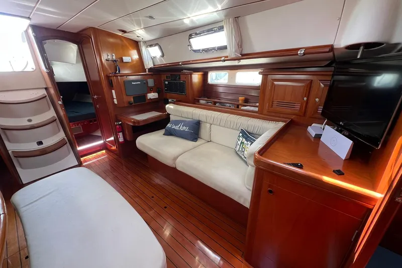 Slide: The Image of Interior of 2001 Beneteau Oceanis 461 yacht with wooden flooring and cozy seating area. - 22