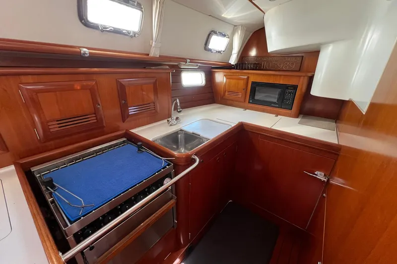 Slide: The Image of Interior of 2001 Beneteau Oceanis 461 yacht kitchen with wood cabinetry and modern appliances. - 26