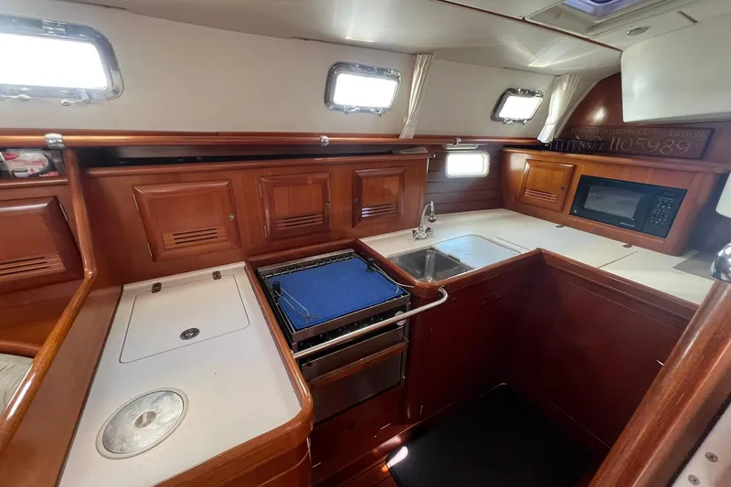 Slide: The Image of Interior of 2001 Beneteau Oceanis 461 yacht kitchen with wood cabinetry and modern appliances. - 27