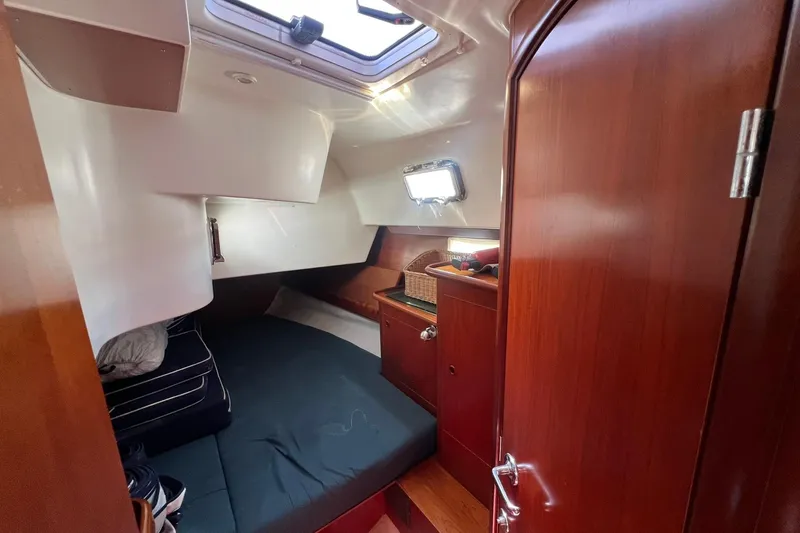 Slide: The Image of Cozy cabin interior of 2001 Beneteau Oceanis 461 sailboat with wooden finish and bedding. - 32