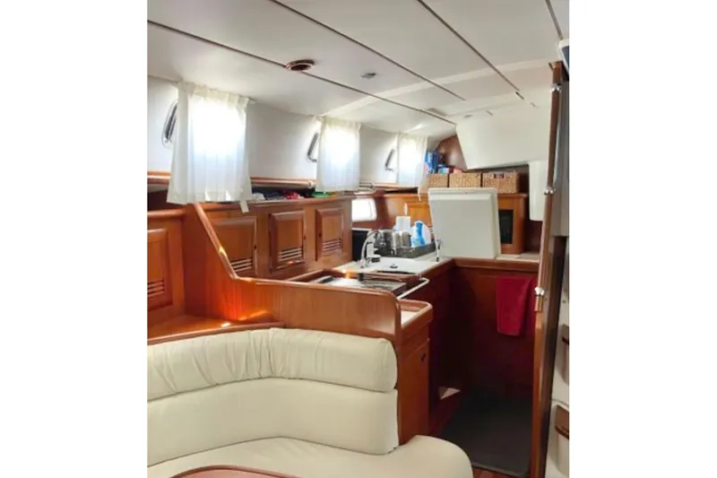 Slide: The Image of Interior of 2001 Beneteau Oceanis 461 yacht, featuring a cozy kitchen and seating area. - 6
