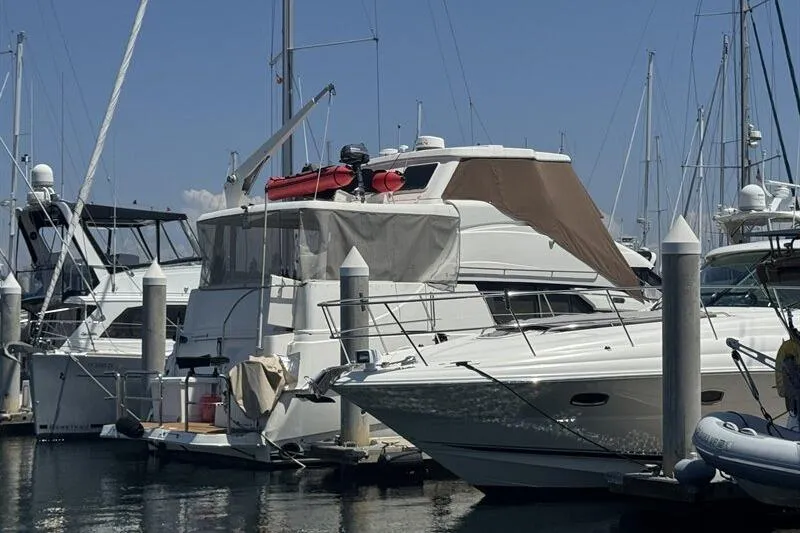 Slide: The Image of 2000 Silverton 453 Motor Yacht docked at marina under clear blue sky. - 2