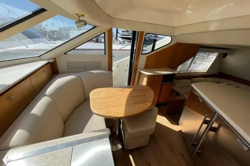 Slide: The Image of Interior of 2000 Silverton 453 Motor Yacht with cozy seating and wooden table. - 20