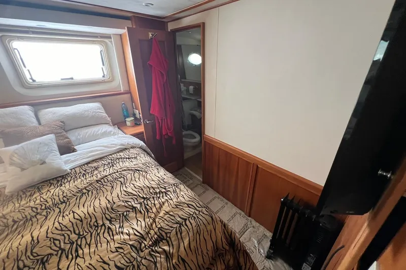 Slide: The Image of Cozy bedroom in 2000 Silverton 453 Motor Yacht with patterned bedding and window view. - 27