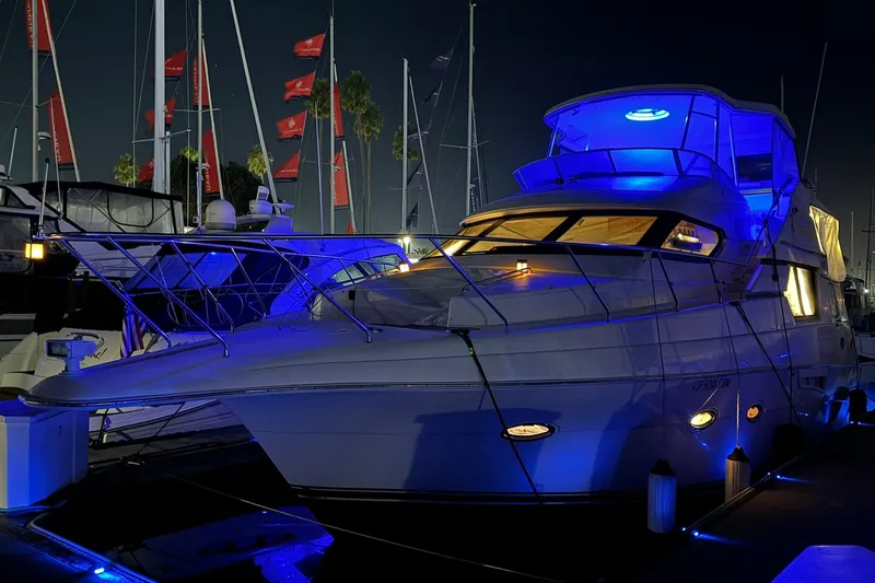 Slide: The Image of 2000 Silverton 453 Motor Yacht illuminated with blue lights at night in a marina. - 3