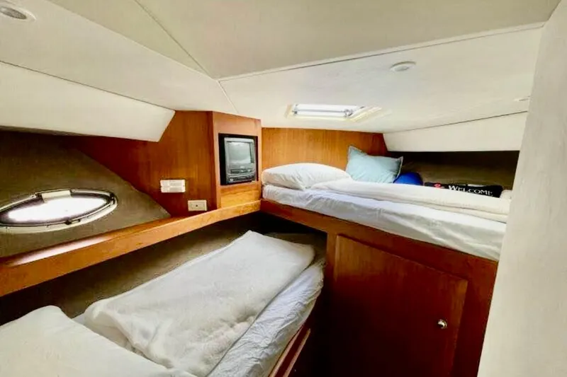 Slide: The Image of 2000 Silverton 453 Motor Yacht cabin with twin beds and porthole window. - 31