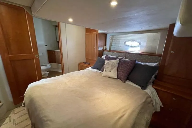 Slide: The Image of Luxurious bedroom interior of 2000 Silverton 453 Motor Yacht with cozy bedding and wooden accents. - 34