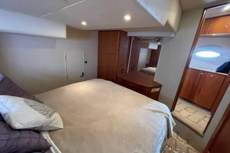 Slide: The Image of Interior of 2000 Silverton 453 Motor Yacht bedroom with cozy bed and wooden cabinetry. - 35