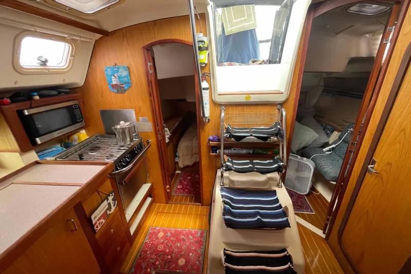 Slide: The Image of Interior of a 2000 Hunter 410 sailboat featuring a cozy kitchen and sleeping area. - 10