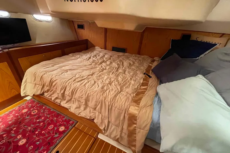 Slide: The Image of Cozy cabin interior of a 2000 Hunter 410 yacht with a comfortable bed and decorative rug. - 11