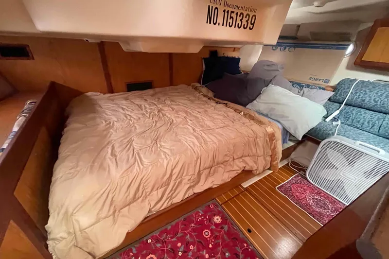 Slide: The Image of Cozy cabin interior of 2000 Hunter 410 sailboat with bed and seating area. - 12