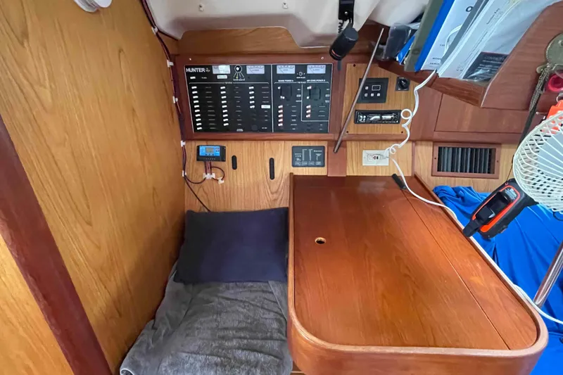 Slide: The Image of Interior of a 2000 Hunter 410 sailboat with control panel and wooden desk. - 20