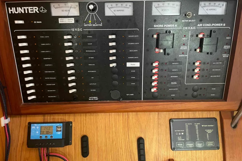 Slide: The Image of Electrical control panel of a 2000 Hunter 410 boat with various switches and meters. - 21