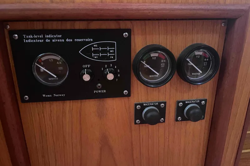Slide: The Image of Control panel of a 2000 Hunter 410 boat with tank-level indicators and macerator switches. - 23