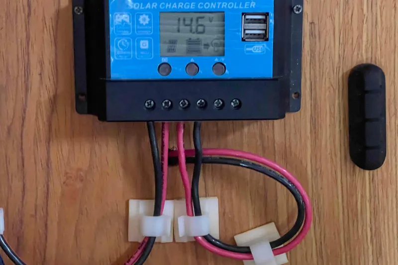 Slide: The Image of Solar charge controller with digital display and USB ports, mounted on wooden surface. Hunter 410, 2000 model. - 25
