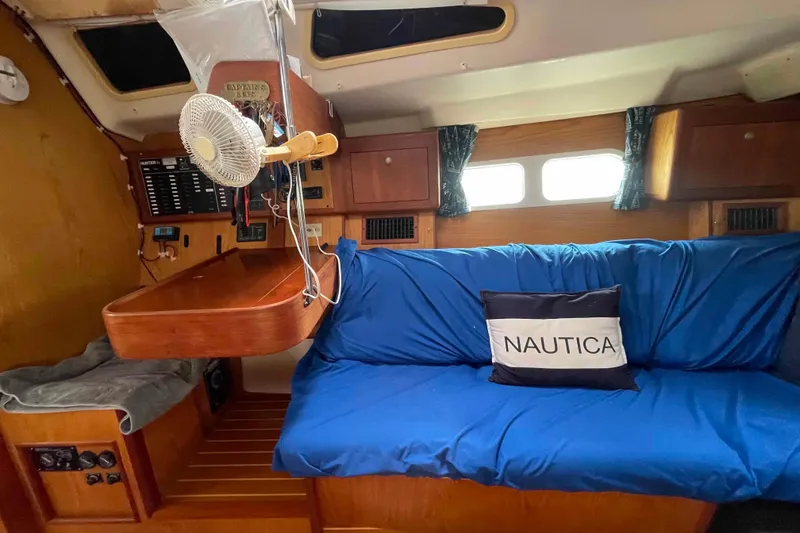 Slide: The Image of Interior of a 2000 Hunter 410 sailboat with blue seating and nautical decor. - 27