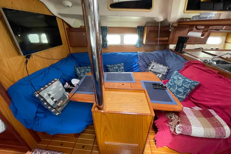 Slide: The Image of Cozy interior of a 2000 Hunter 410 sailboat with colorful cushions and a mounted TV. - 29