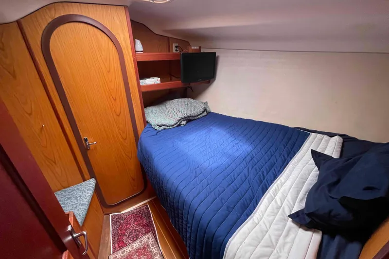 Slide: The Image of Cozy cabin interior of a 2000 Hunter 410 sailboat with a blue bedspread. - 30