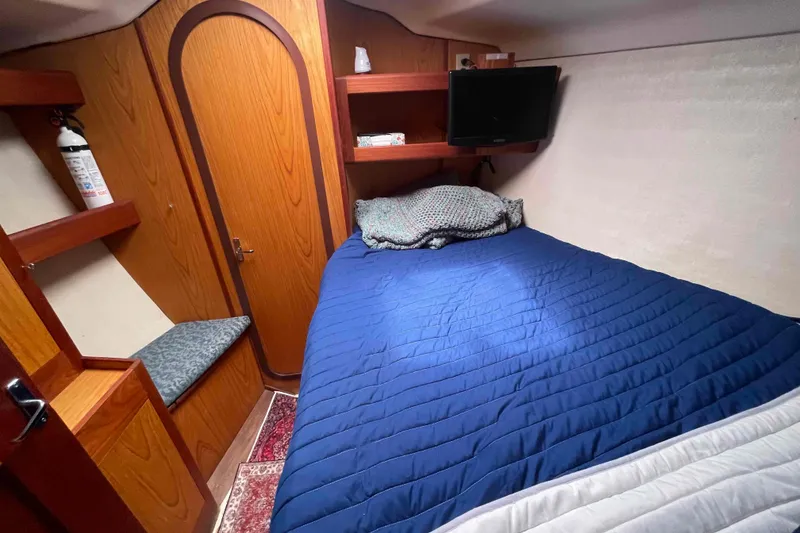 Slide: The Image of Cozy cabin interior of 2000 Hunter 410 sailboat with blue bedding and wooden accents. - 31
