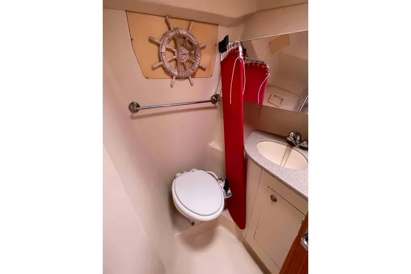 Slide: The Image of Compact boat bathroom with toilet, sink, and nautical decor in a 2000 Hunter 410 model. - 32