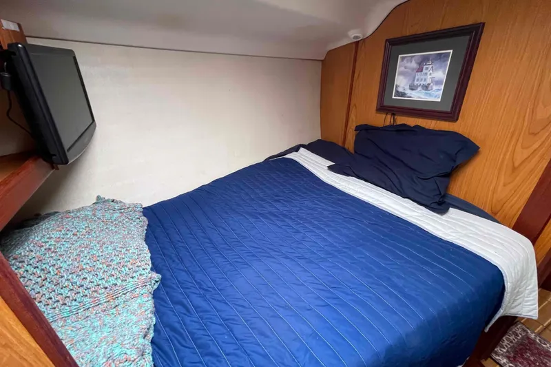 Slide: The Image of Cozy cabin bedroom in 2000 Hunter 410 sailboat with blue bedding and wall art. - 34