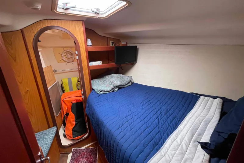 Slide: The Image of Cozy cabin interior of 2000 Hunter 410 sailboat with blue bedding and wooden accents. - 35