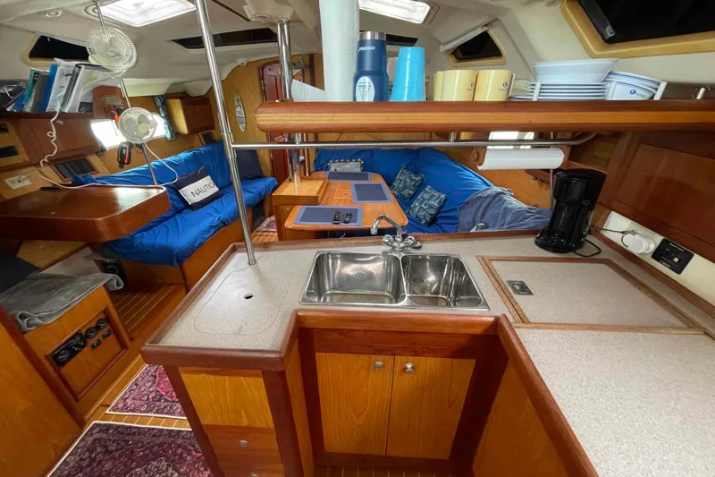 Slide: The Image of Interior of a 2000 Hunter 410 sailboat featuring a cozy kitchen and seating area. - 38