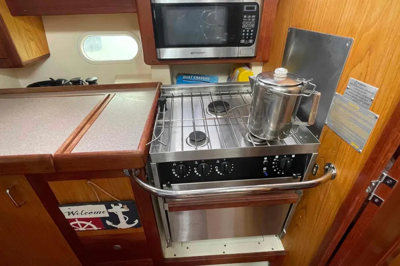 Slide: The Image of Compact kitchen in a 2000 Hunter 410 yacht with stove, microwave, and kettle. - 39