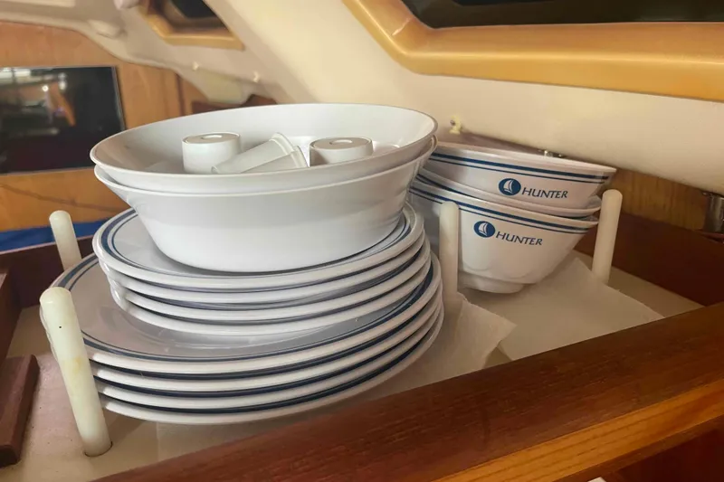 Slide: The Image of Stacked Hunter-branded dishes in a 2000 Hunter 410 yacht interior. - 42