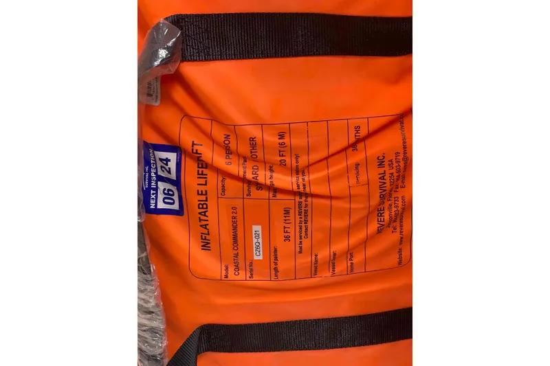 Slide: The Image of Orange inflatable liferaft with inspection date, capacity, and manufacturer details. Hunter 410, 2000 model. - 46