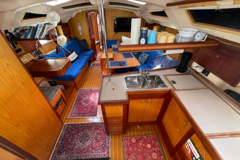 Slide: The Image of Interior of a 2000 Hunter 410 sailboat with cozy seating and kitchen area. - 5