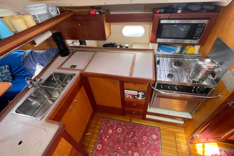 Slide: The Image of Compact kitchen in a 2000 Hunter 410 sailboat with stove, sink, and microwave. - 6